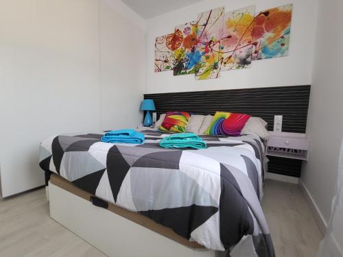 Apartamento Martinez del Campo في برغش: غرفة نوم مع سرير كبير مع وسائد ملونة