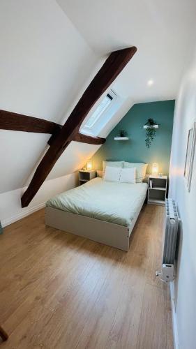 une chambre avec un grand lit dans un grenier dans l'établissement Le Champs des Oiseaux, à Rouen