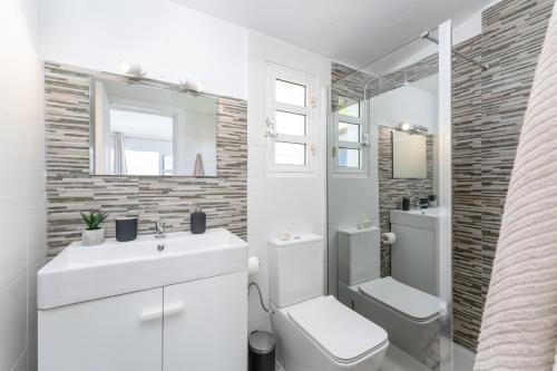 馬斯帕洛馬斯的住宿－Barefoot Bungalow，白色的浴室设有水槽和卫生间。