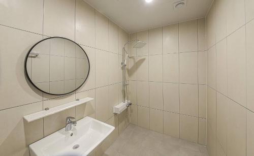 a white bathroom with a sink and a mirror at Geoje Dongbeck Hotel Gohyeon in Geoje