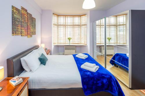 - une chambre avec un grand lit et 2 fenêtres dans l'établissement ALTIDO 2-bed flat near Notting Hill, à Londres