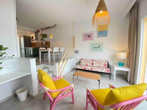 a living room with colorful chairs and a couch at La Casa de las Hespérides in Morro del Jable