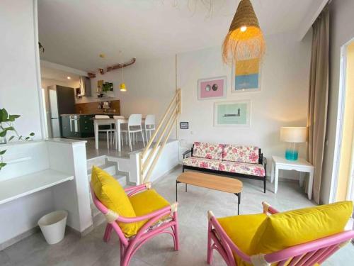 un soggiorno con sedie colorate e un divano di La Casa de las Hespérides a Morro del Jable