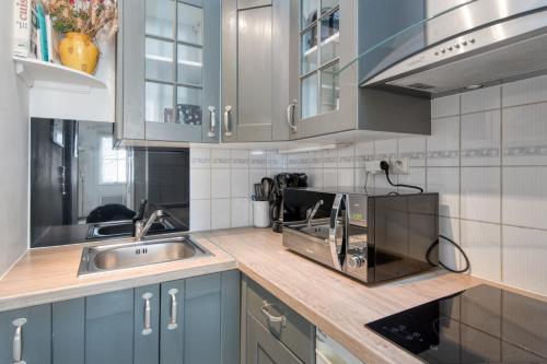 une cuisine avec des armoires bleues et un évier dans l'établissement Studio Cyclade, proche du port de Saint Martin, à Saint-Martin-de-Ré