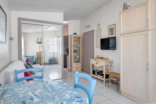 une chambre avec un lit, un bureau et une télévision dans l'établissement Studio Cyclade, proche du port de Saint Martin, à Saint-Martin-de-Ré