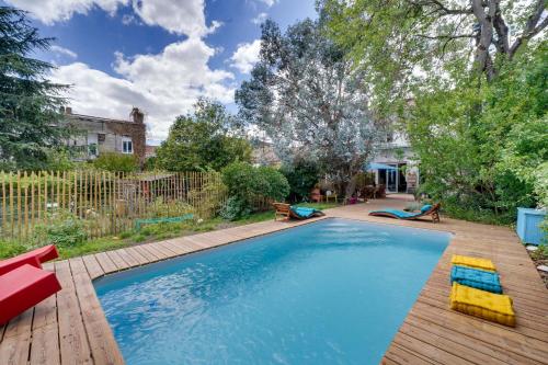 une piscine avec une terrasse en bois et une arrière-cour dans l'établissement Bordeaux centre, Appartement privatif et 5 chambres privées, piscine, parking, à Bordeaux