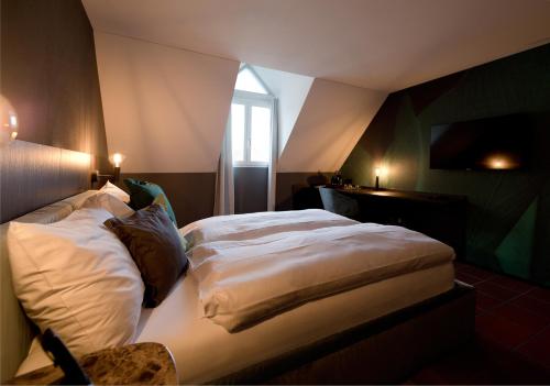 a large bed in a room with a window at Hotel Sonne Sissach in Sissach