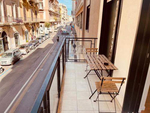 Un balcón con una mesa y sillas en una calle de la ciudad. en Futura Exclusive Suite 1, en Bari