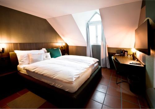 Hotel Sonne Sissach في سيساتش: غرفة نوم بسرير ومكتب ونافذة