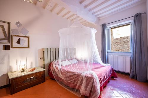 a bedroom with a bed with a mosquito net at Angolo Della cei in Terricciola