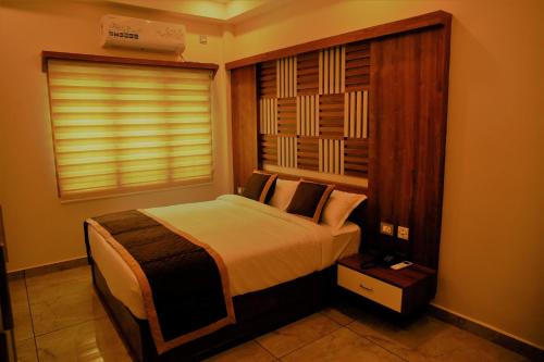 a bedroom with a bed and a window at AGS Residency in Ernakulam