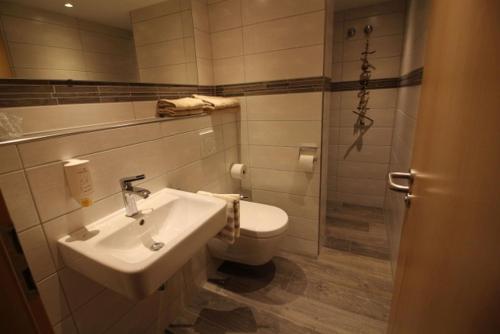 a bathroom with a sink and a toilet at Hotel Garni Café Räpple in Bad Peterstal