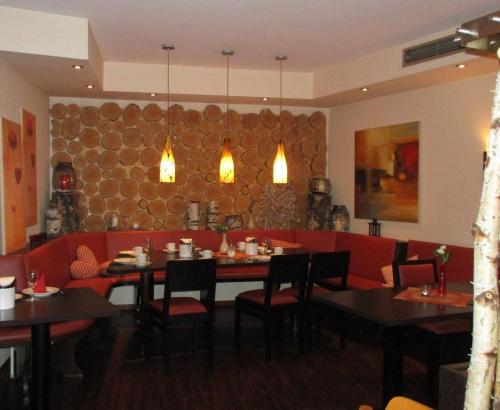a dining room with a table and red chairs at Hotel Garni Café Räpple in Bad Peterstal