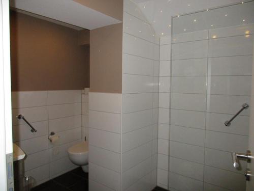 a bathroom with a toilet and a shower stall at Hotel Garni Café Räpple in Bad Peterstal