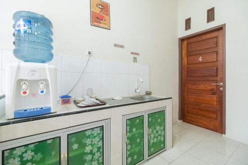 uma cozinha com um lavatório e uma bancada em RedDoorz Syariah at D'Ostha Residence em Bukittinggi