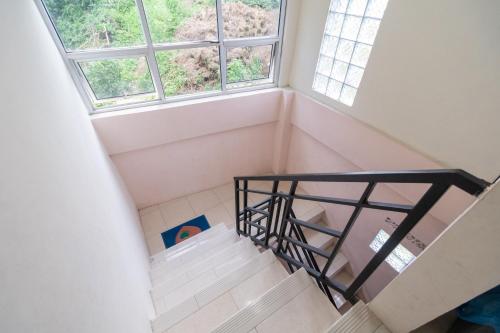 a staircase in a room with two windows at RedDoorz Syariah at D'Ostha Residence in Bukittinggi