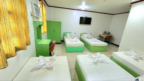 a room with two beds and a tv in it at Demiren Hotel in Cagayan de Oro