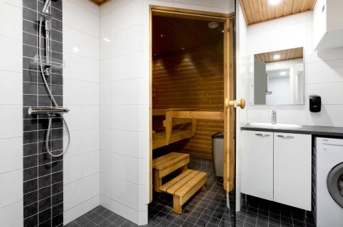 een badkamer met een douche en een wastafel bij Holiday Club Vierumäki Apartments in Vierumäki