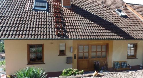 une maison avec un toit en carrelage et une porte dans l'établissement Ferienwohnung Fleckenstein, à Eichenbühl