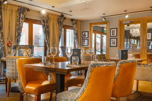 a restaurant with a table and chairs and wine glasses at The White Horse Hotel, Romsey, Hampshire - The Coaching Inn Group in Romsey