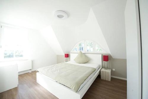 a white bedroom with a white bed and a window at Naturferienhaus 1 in Mellnitz
