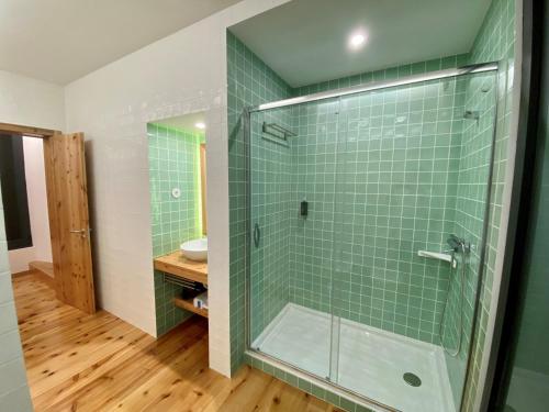 a bathroom with a shower with green tiles at Nature & Sea - Casa Vinhateira East Duplex in Caloura