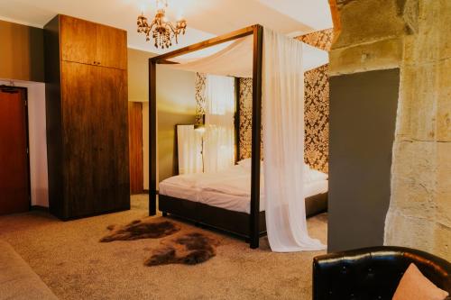 a bedroom with a canopy bed with a mirror at Wellness Hotel Liberecká Výšina in Liberec