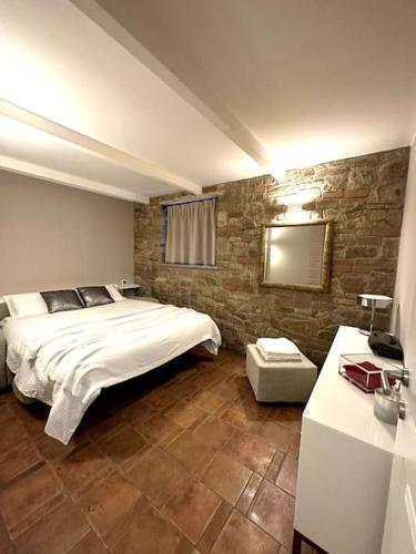 a bedroom with a large bed and a stone wall at Appartamento Ebhouse in Capiago Intimiano