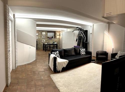 ein Wohnzimmer mit einem schwarzen Sofa und einem Tisch in der Unterkunft Appartamento Ebhouse in Capiago Intimiano
