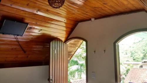 a living room with a wooden ceiling and two windows at Pousada Portal de Lumiar in Lumiar