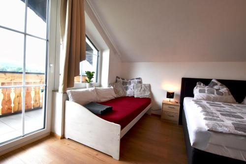a bedroom with a bed and a large window at Almblick Energiequelle in Bad Mitterndorf