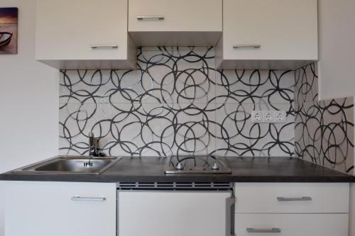 a kitchen with a sink and a patterned wall at Almblick Energiequelle in Bad Mitterndorf