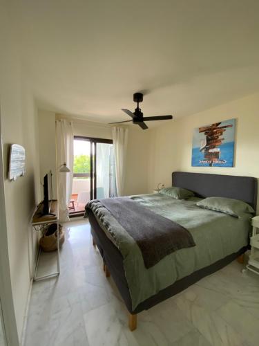 sypialnia z łóżkiem i wentylatorem sufitowym w obiekcie Alcaidesa Golf and Beach Resort w mieście La Alcaidesa