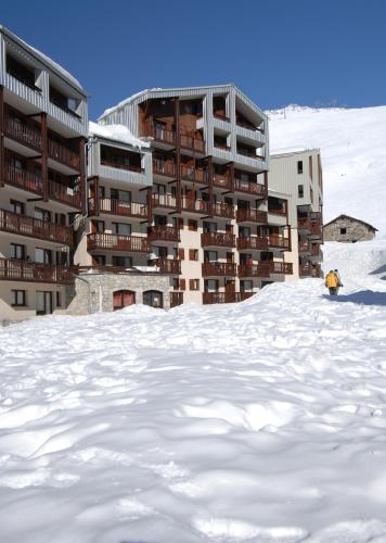 a person standing in the snow in front of a building at Résidence Odalys Le Hameau du Borsat in Tignes