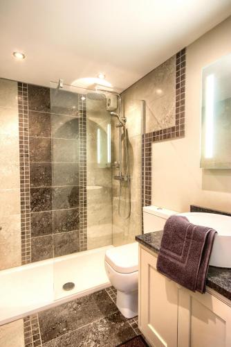 a bathroom with a shower and a toilet and a sink at Sea Spray in Sheringham