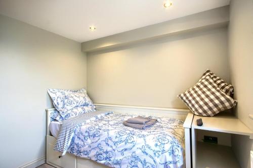 een kleine slaapkamer met een bed en kussens bij Sea Spray in Sheringham