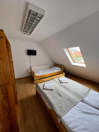 1 dormitorio con 2 camas individuales y ventana en Antal Guesthouse, en Ghimeş-Făget