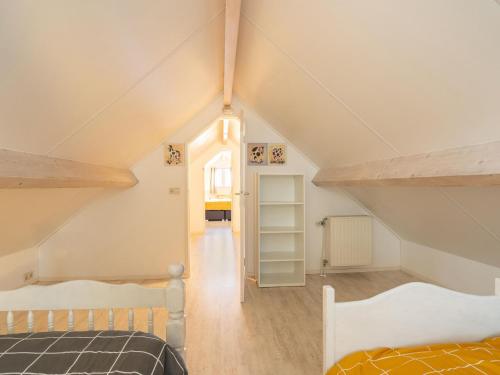 een zolderkamer met 2 bedden en een trap bij Inviting holiday home in Baarland with terrace in Baarland