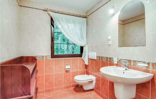 a bathroom with a sink and a toilet and a window at Awesome Home In Pobierowo With 4 Bedrooms in Pobierowo