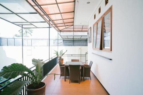 瑪琅的住宿－Urbanview Hotel Griya Surya Malang by RedDoorz，一间带桌椅的用餐室