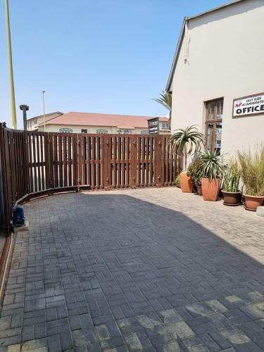 a patio with a wooden fence and some plants at Eazy Sleep Accommodation in Swakopmund