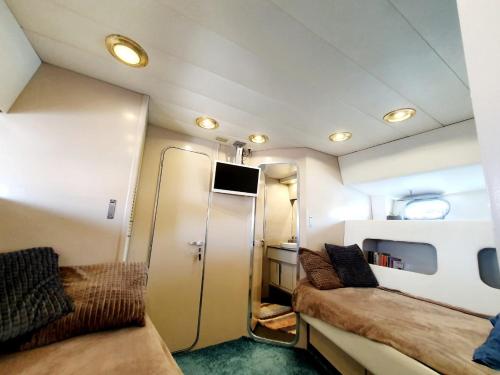 a small room with two beds and a refrigerator at Loc de cabines sur Yacht in Gruissan
