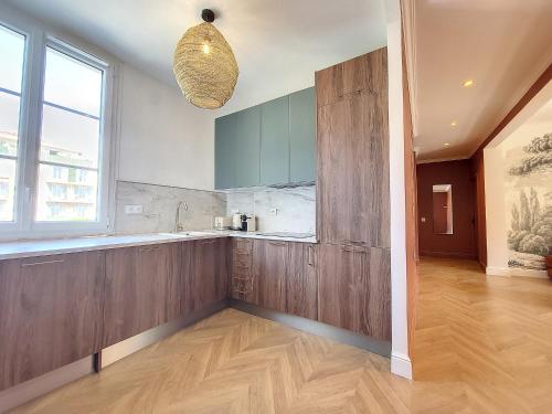 une cuisine avec des placards en bois et une grande fenêtre dans l'établissement Nestor&Jeeves - PORT LYMPIA - Port area - Close Old Town, à Nice