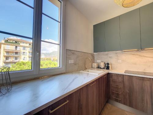 une cuisine avec un évier et une grande fenêtre dans l'établissement Nestor&Jeeves - PORT LYMPIA - Port area - Close Old Town, à Nice