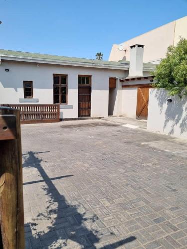 a white building with a gate and a driveway at Eazy Sleep Accommodation in Swakopmund