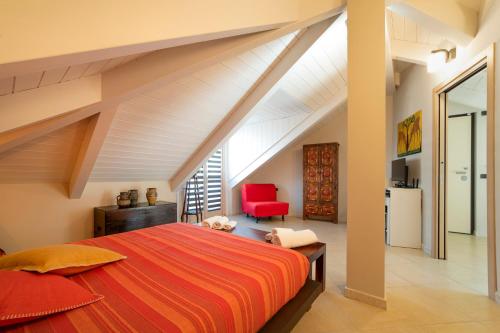 a bedroom with a large bed and a red chair at TO-Housing3, luce e relax al centro di Torino in Turin