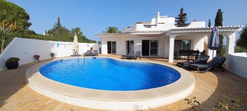 a swimming pool in front of a house at Casa Gemeas in Carvoeiro