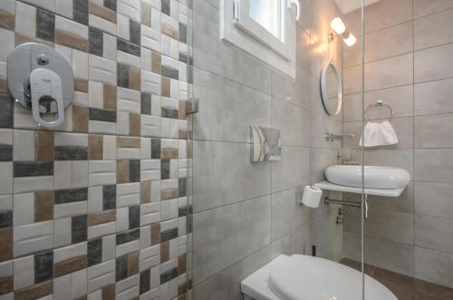 a bathroom with a toilet and a sink and a mirror at Saint George Hotel in Naxos Chora