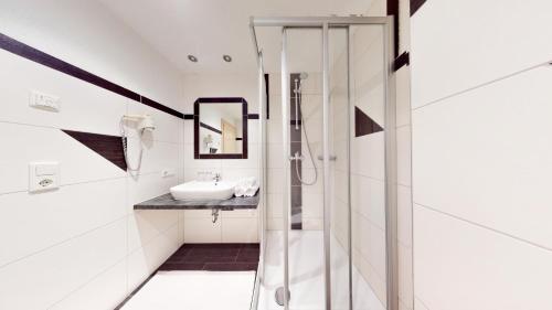 Haus Isabella Apartments - Oetz في أوتز: حمام مع دش زجاجي ومغسلة