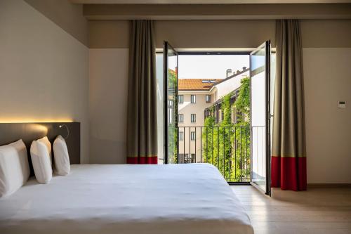 a bedroom with a large bed and a large window at Savona 18 Suites in Milan